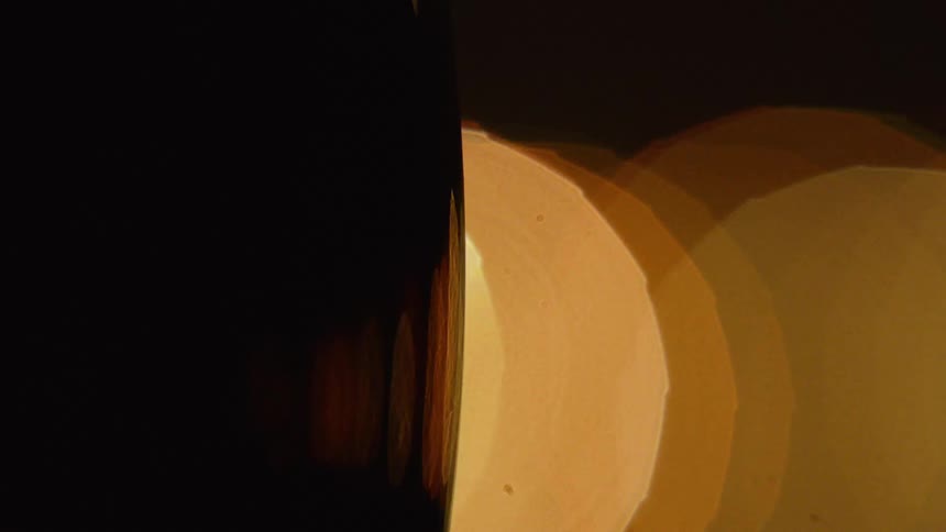 The image shows a dark contrast on the left side and circles that are blurred golden bokeh effect on the right side