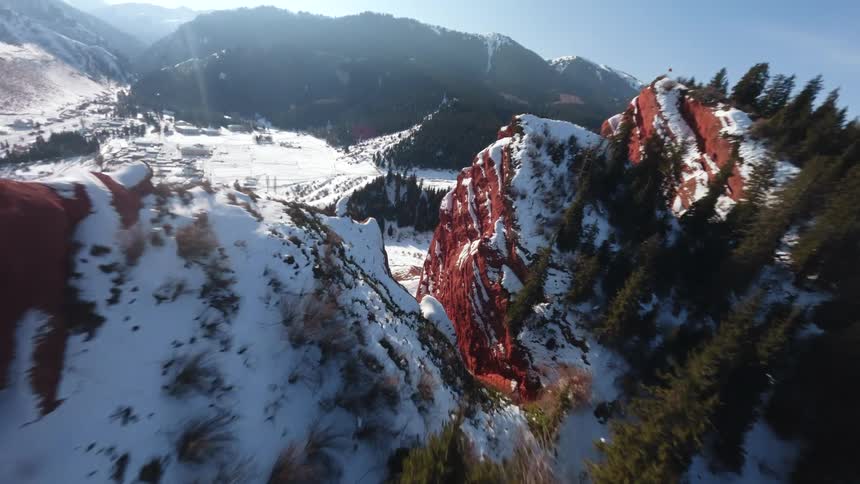 Aerial view of snow on red rock mountain canyons and through the valley