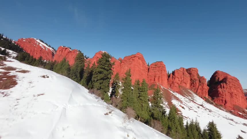 Aerial footage of a rocky mountain range with snow on its slopes