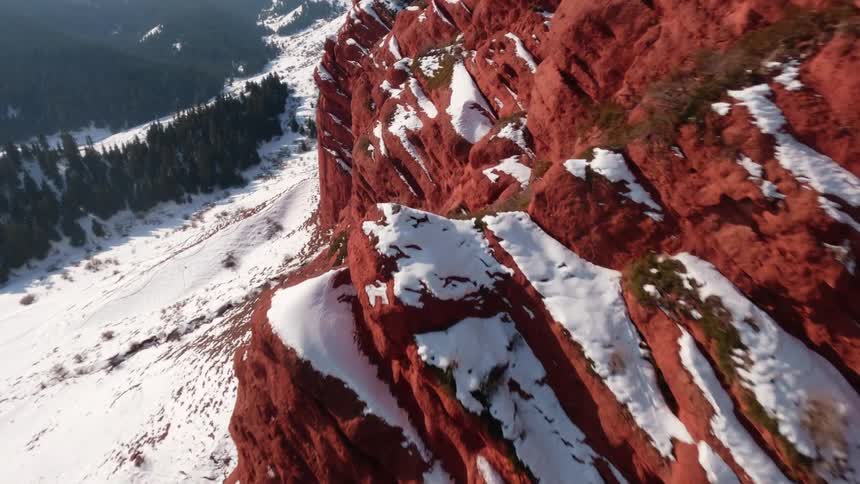 Red mountains are topped with white snow