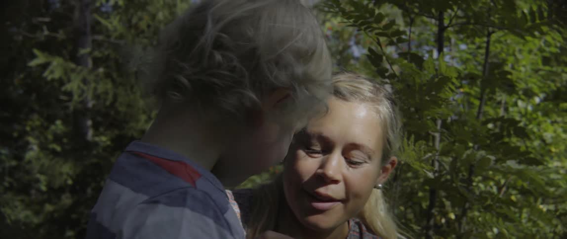 Young mother talking to her toddler boy while sitting together on a sunny day