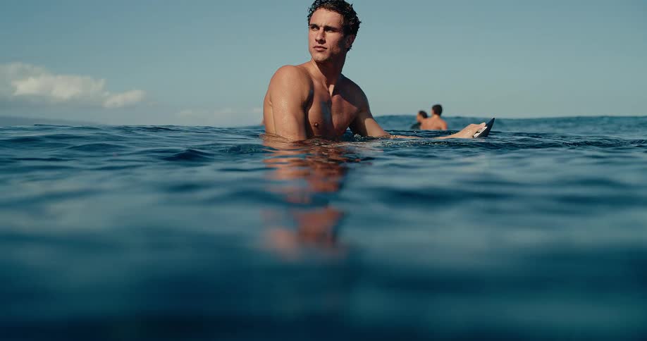 A man sitting on a surfboard in the ocean
