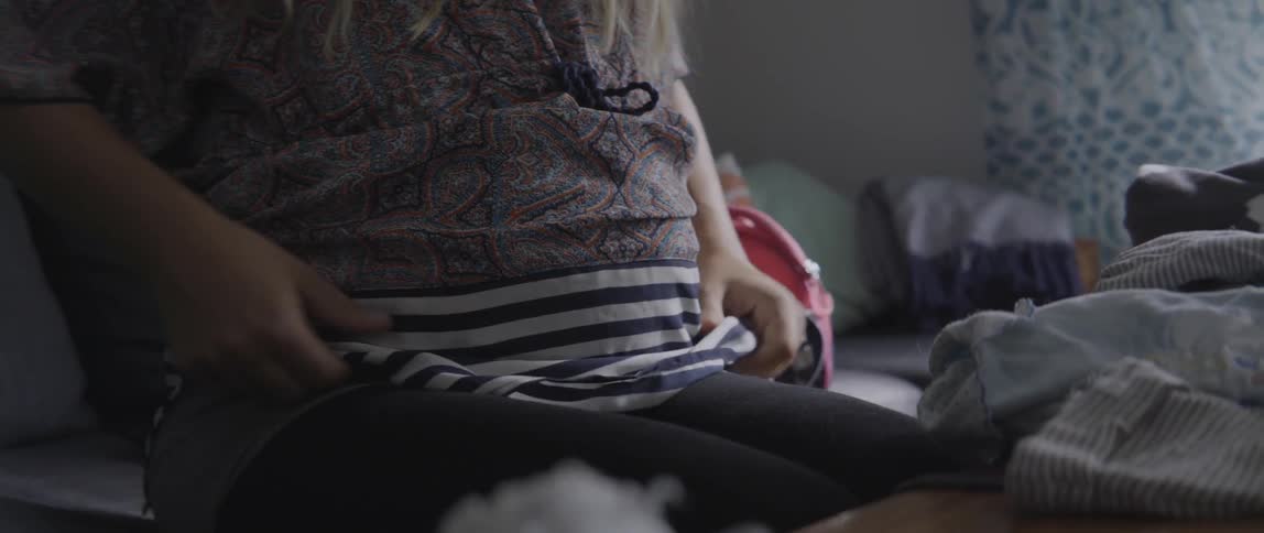 Heartwarming footage of a pregnant woman touching her belly in a living space.