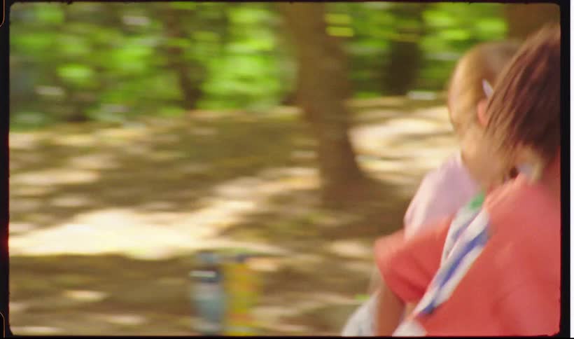 Children running and playing together in a wooded outdoor area