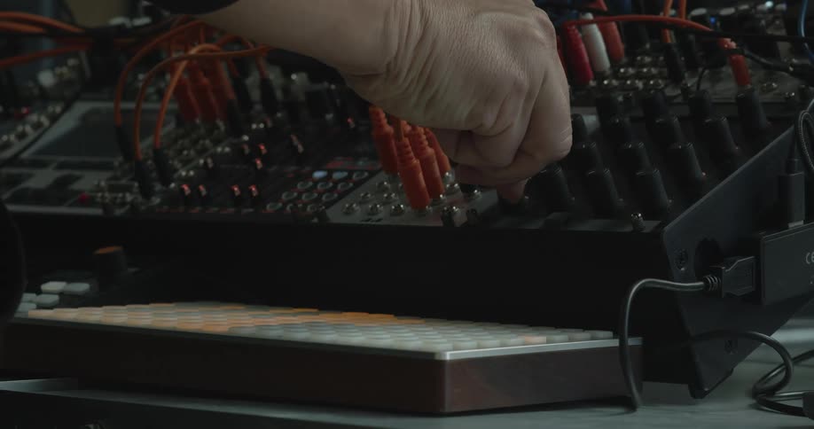 Man adjusts a knob before pushing a panel button in a studio
