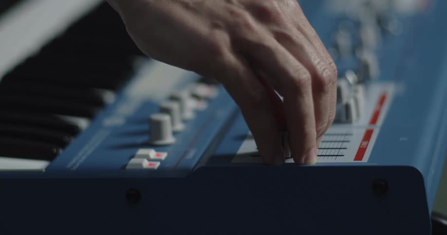 A person adjusting knobs on a mixing console