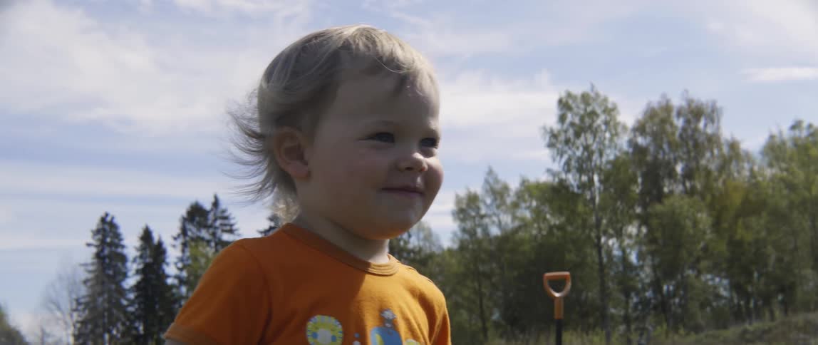 Happy toddler boy and woman high fiving during a playful outdoor activity in summer.