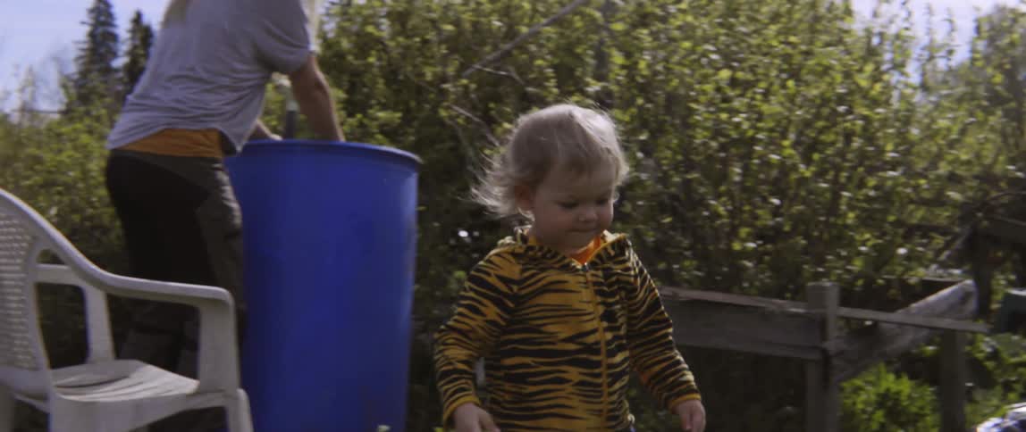 Mother and young son working in a lush outdoor garden during the day