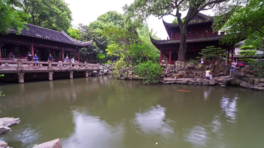 Traditional chinese garden with a pond swimming fish wooden pavilions and surrounding trees