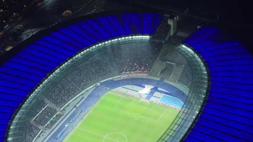 Fans fill a soccer stadium during a night game