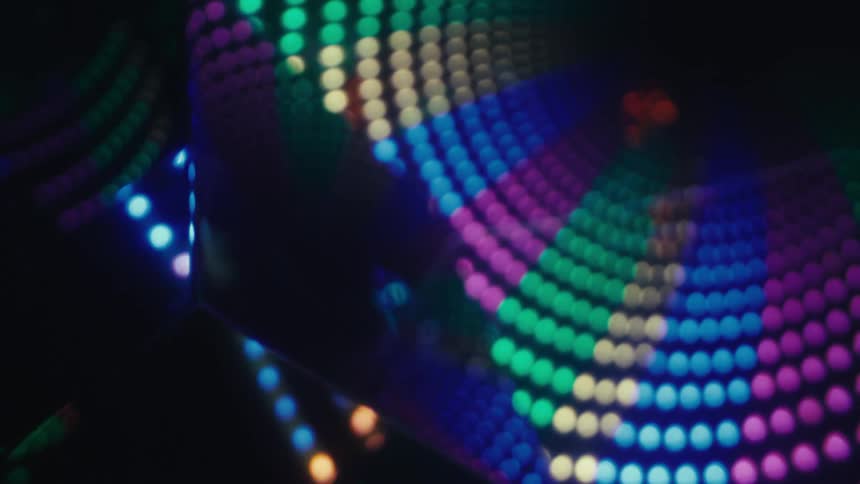 Reflective cubes with colorful light patterns forming curves in a dark environment