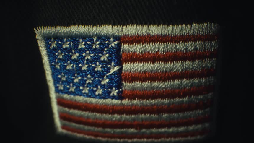 Embroidered united states flag patch stitched onto dark fabric