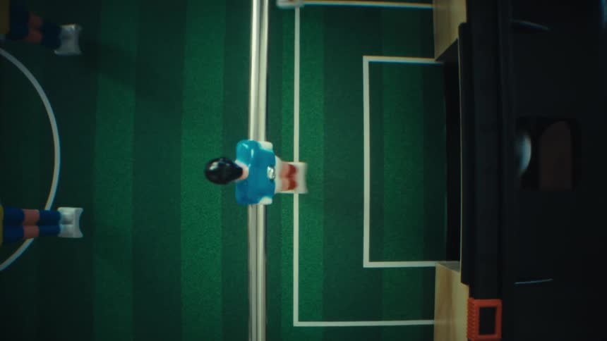 Plastic men in a foosball table move and the ball goes in the goal