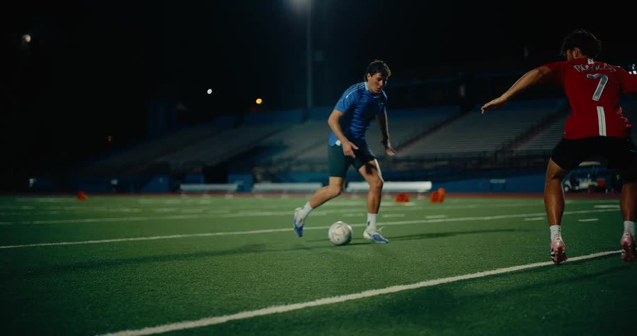 Two men dressed in soccer uniforms are playing soccer on a field