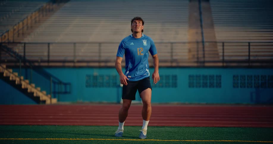 Male soccer player practicing keeping the soccer ball in the air at a sports venue