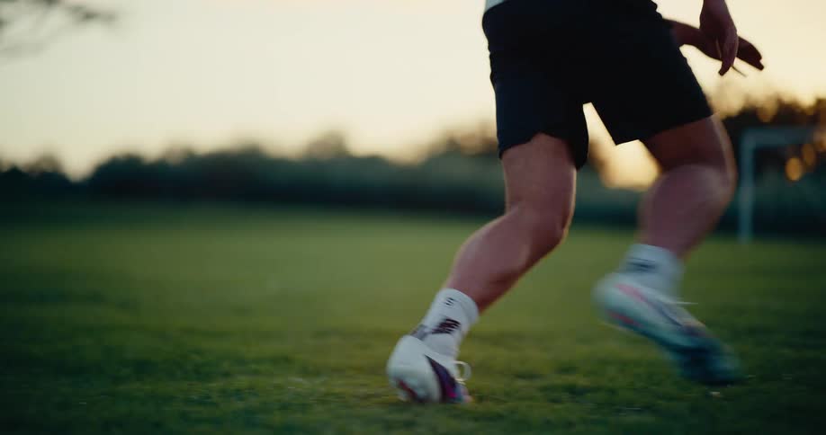 Player wearing number 9 jersey kicking a soccer ball toward the goal on a grass field