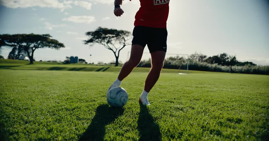 A man kicking a soccer ball on a field