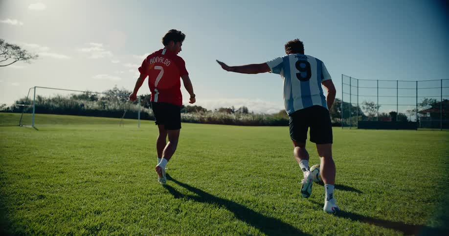 Two people playing soccer on a sunny day