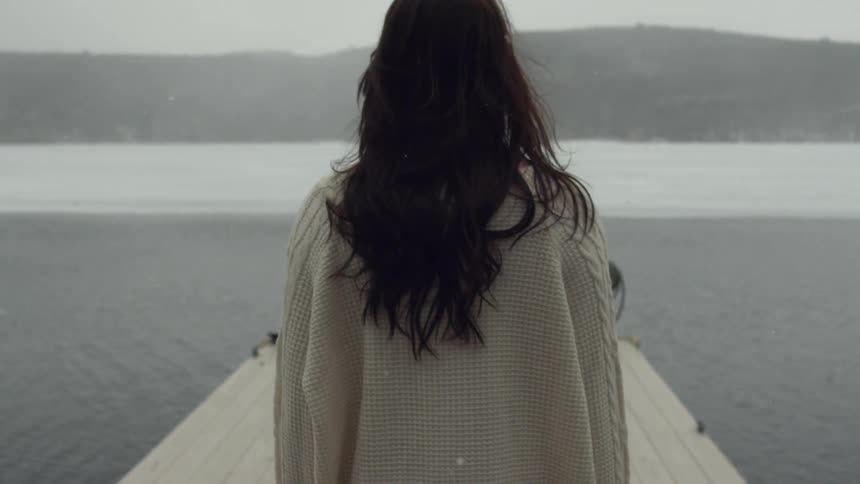 Woman walks on a dock towards water