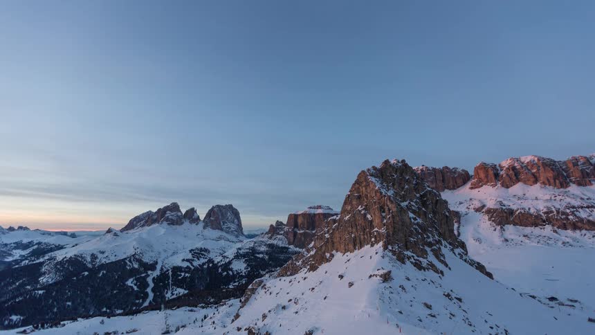 Time lapse the setting over a snow covered mountain range