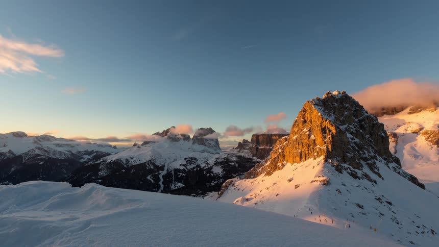 Time lapse of the sun setting on a snow covered mountain range