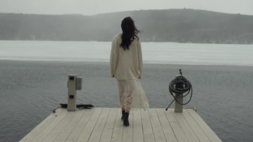 Woman walks on a dock towards water