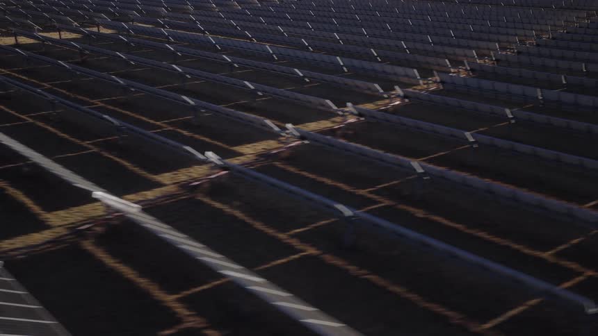 Low aerial shot of solar panels on a large solar farm