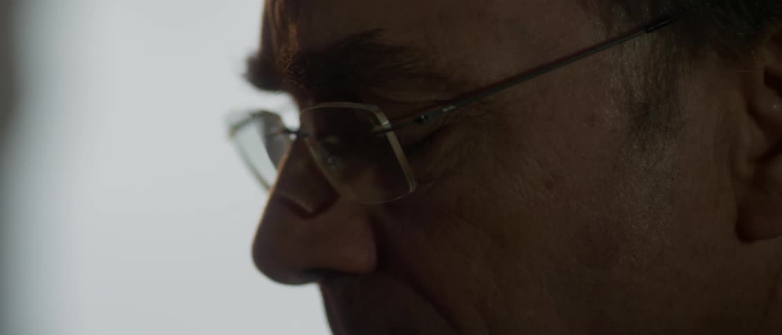 Aim older man wearing reading glasses