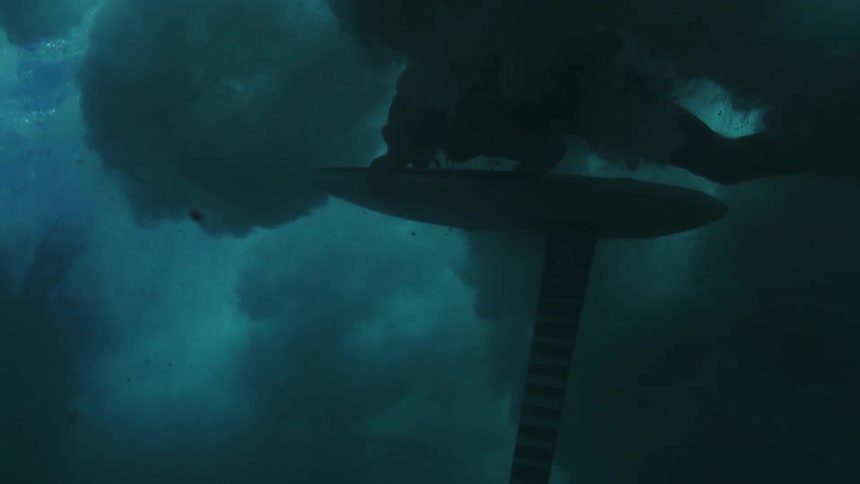 Person underwater holding a hydrofoil board beneath the surface