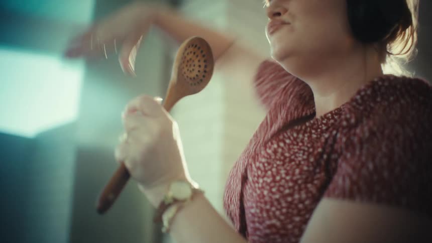 Woman singing with headphones and object in hand