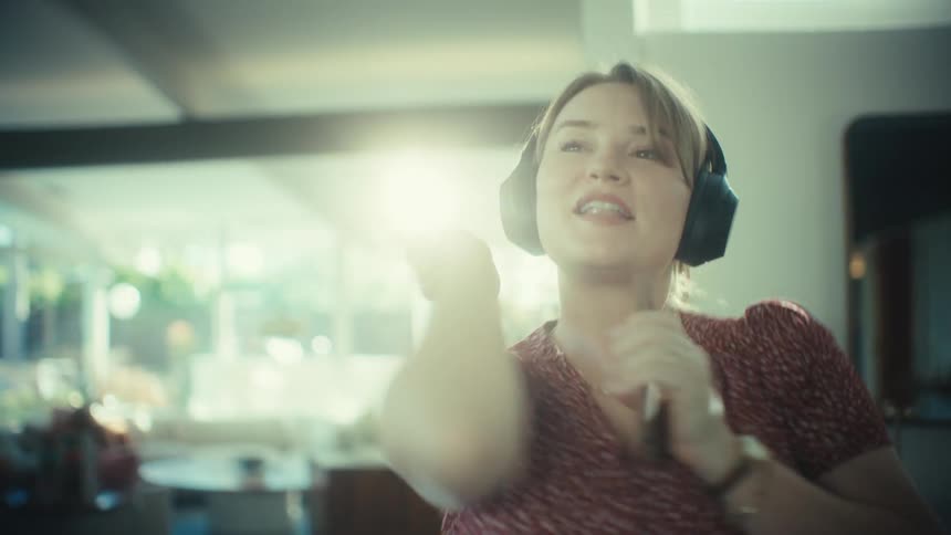 Woman singing with headphones and smartphone