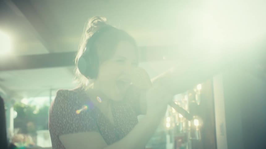 A woman standing in a room singing