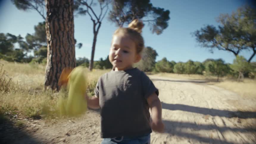 Child running on dirt path with toy