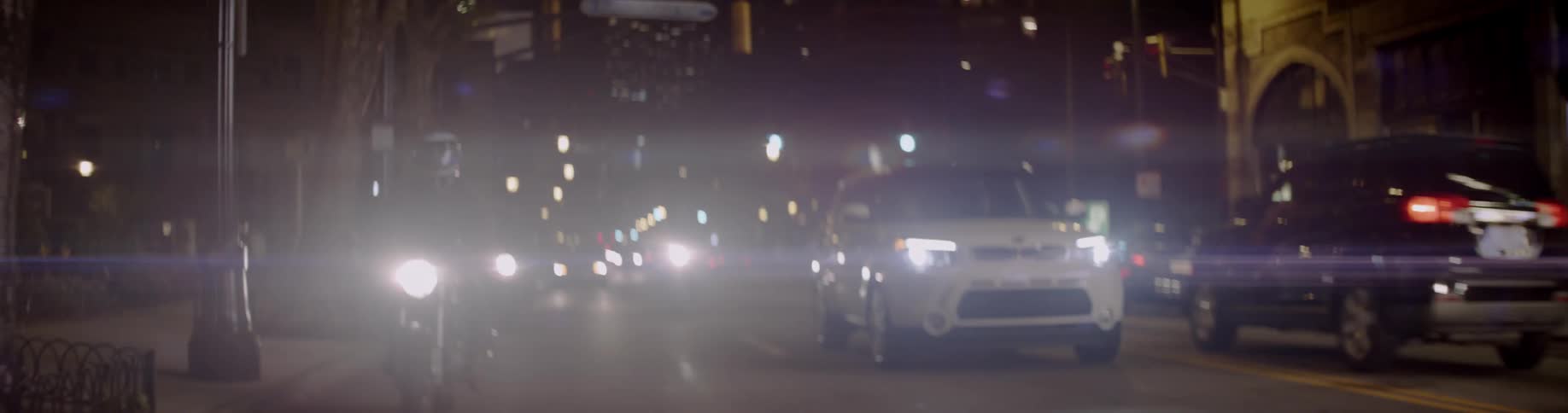 Vehicles travel down the city road at night
