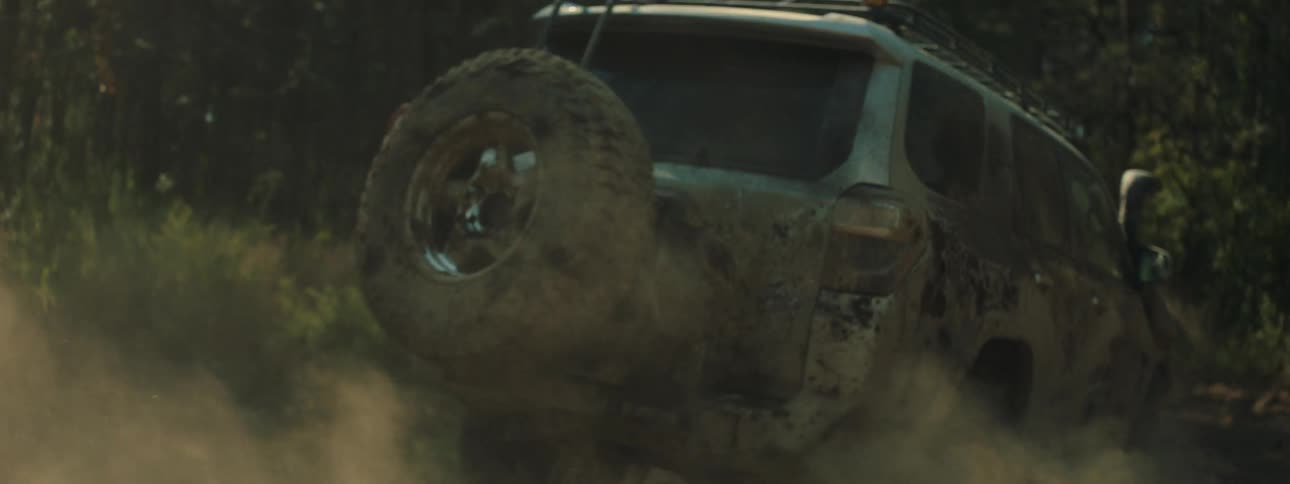 Pickup truck kicking up dust on a trail