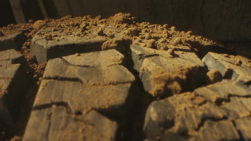 Dirt covering a tire with thick tread on a vehicle