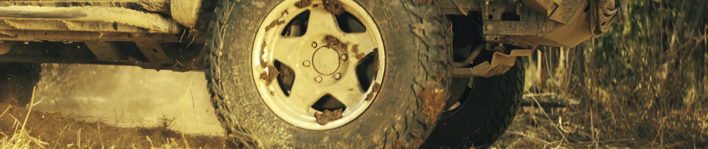 The truck driving off road is covered in dirt