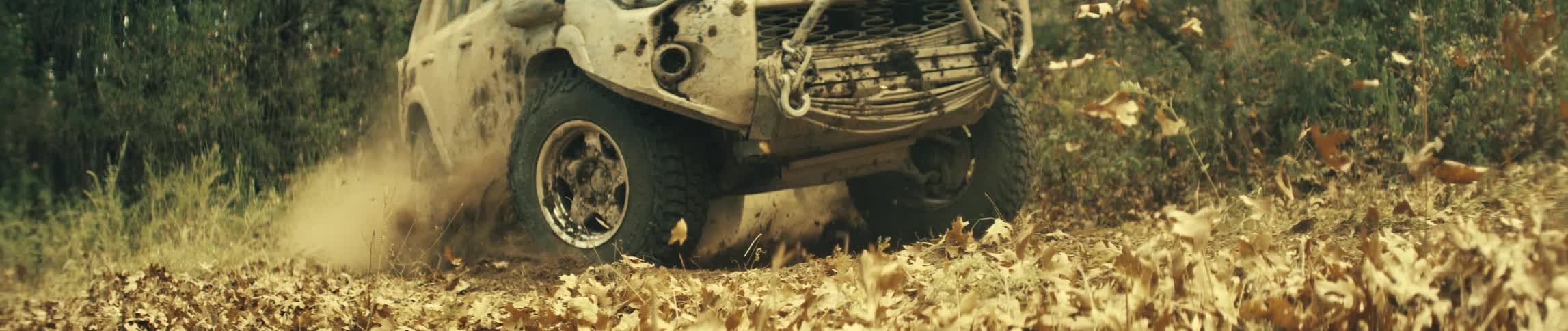 The truck driving off road is speeding in the forest