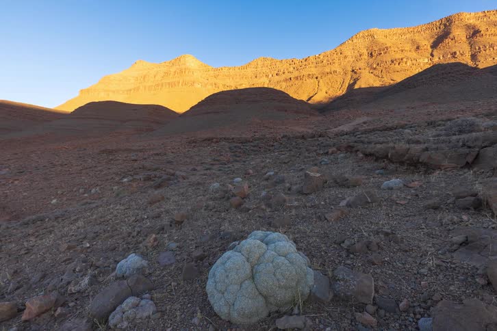 Sunlight creeps across the arid mountainous terrain as the day progresses