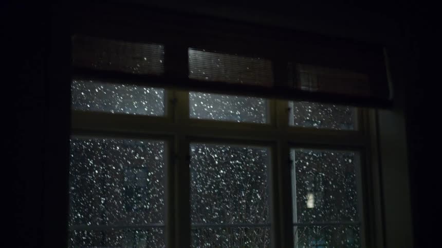 View through windows of snow falling outside