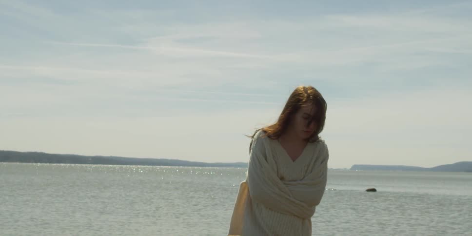 A woman in white is standing by the water