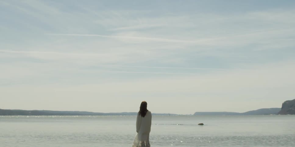 Woman standing beside the shore of a lake