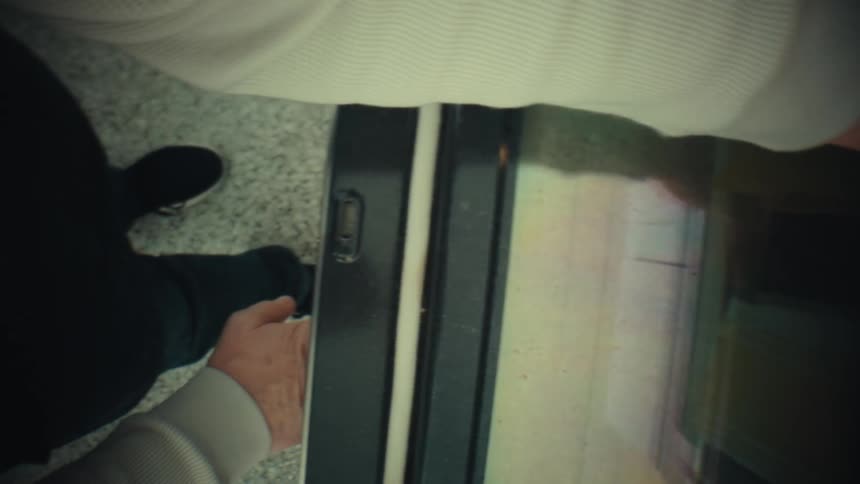 A man in his kitchen placing cookies into the oven