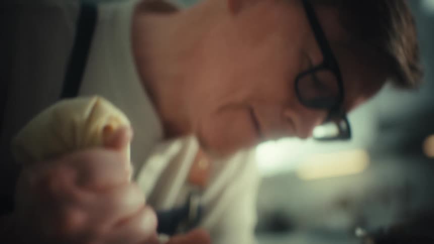 The man is making pastries in the kitchen