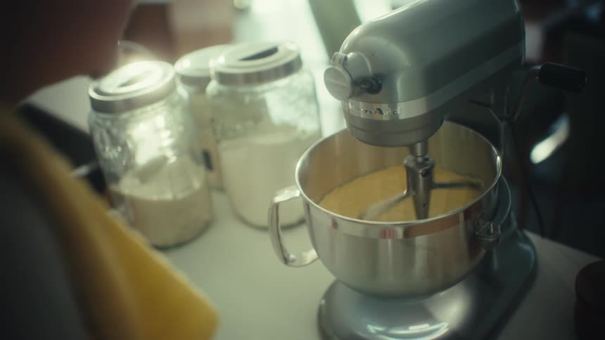 A man mixing food in a stand mixer