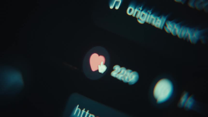 Cursor points to heart icon on a blurred digital interface