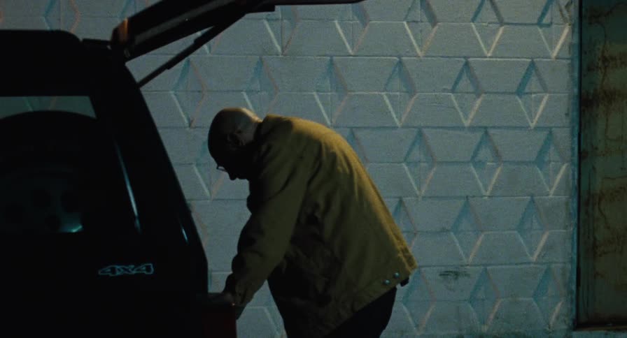 An old man packs his trunk with bags