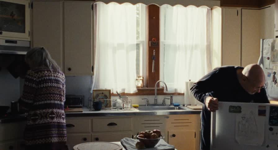 An elderly couple prepare breakfast in the kitchen
