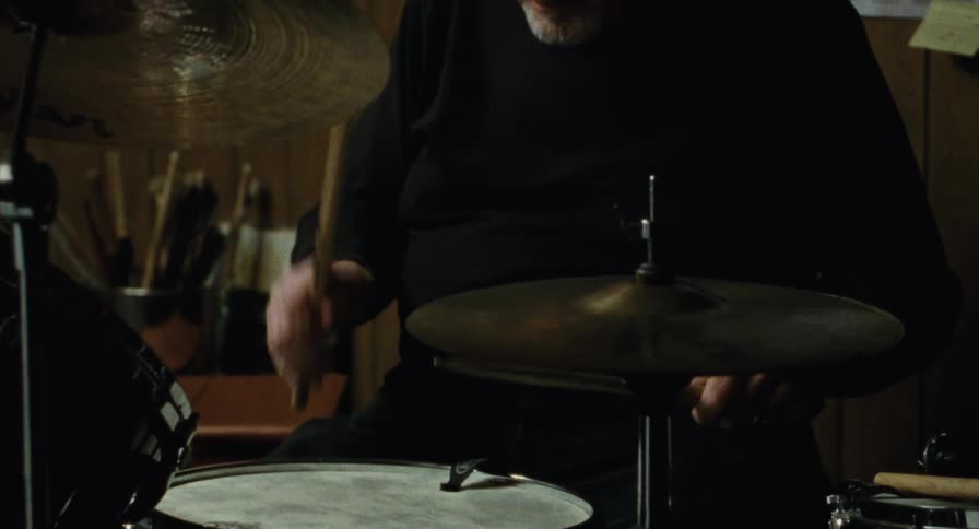 Medium Shot of an old man drumming