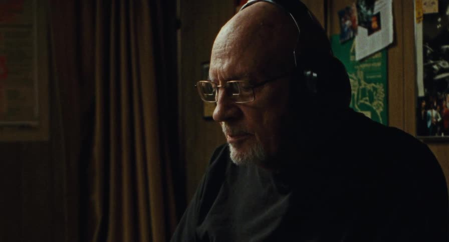Old man listens to music through headphones
